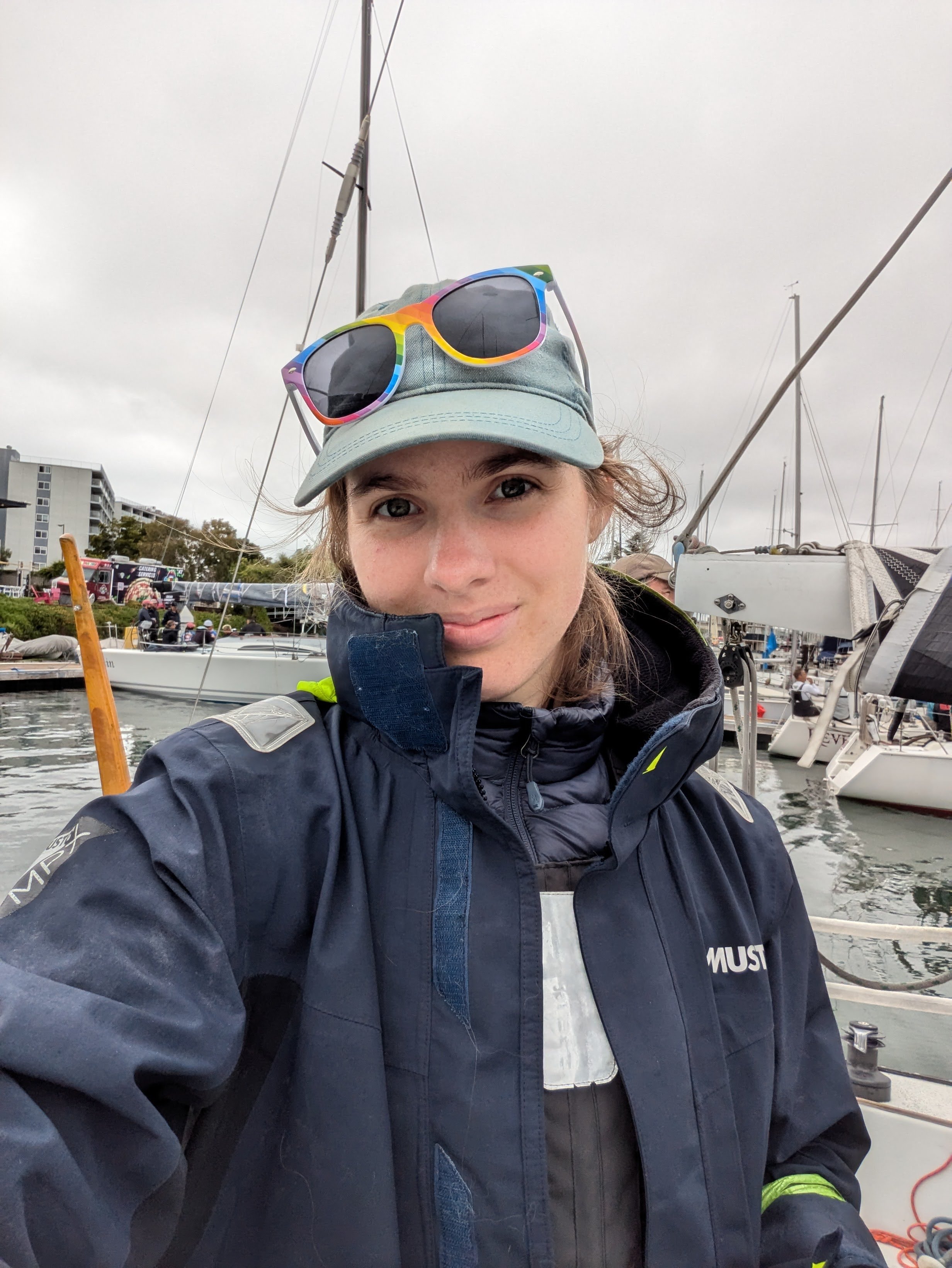 A sailor in a blue coat and rainbow sunglasses